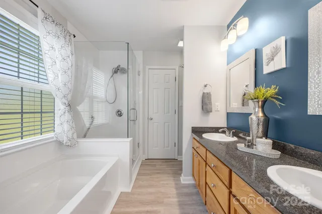 a bathroom with a granite countertop tub sink and mirror