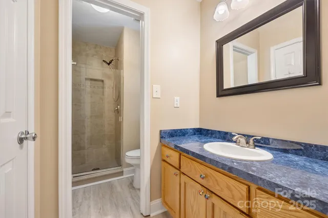 a bathroom with a granite countertop sink toilet and shower