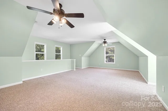 an empty room with windows and ceiling fan