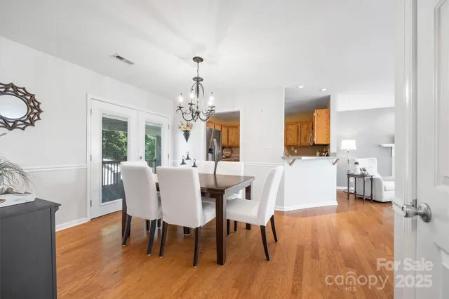 a view of a dining room with furniture wooden floor and chandelier