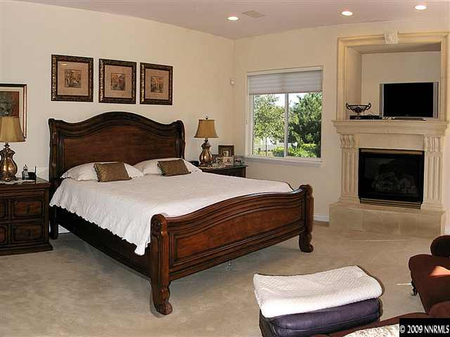 12680 Silver Wolf Road Reno, NV 89511 - Photo 7 of 9 a bedroom with a bed and a fireplace