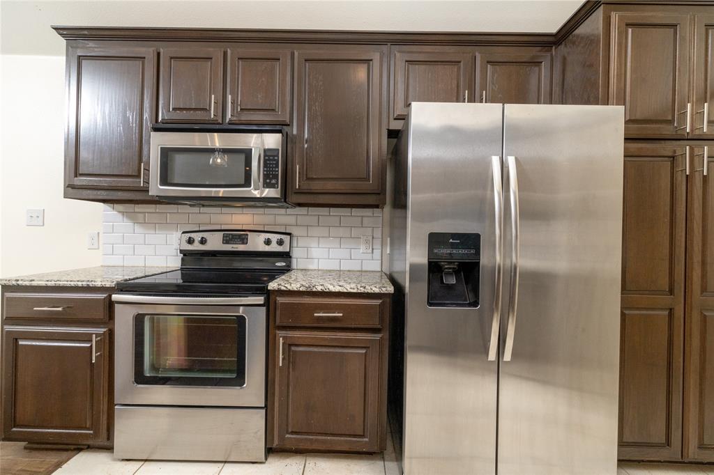 405 Kimbrough Road Azle, TX 76020 - Photo 13 of 39 a kitchen with stainless steel appliances granite countertop a refrigerator stove and microwave