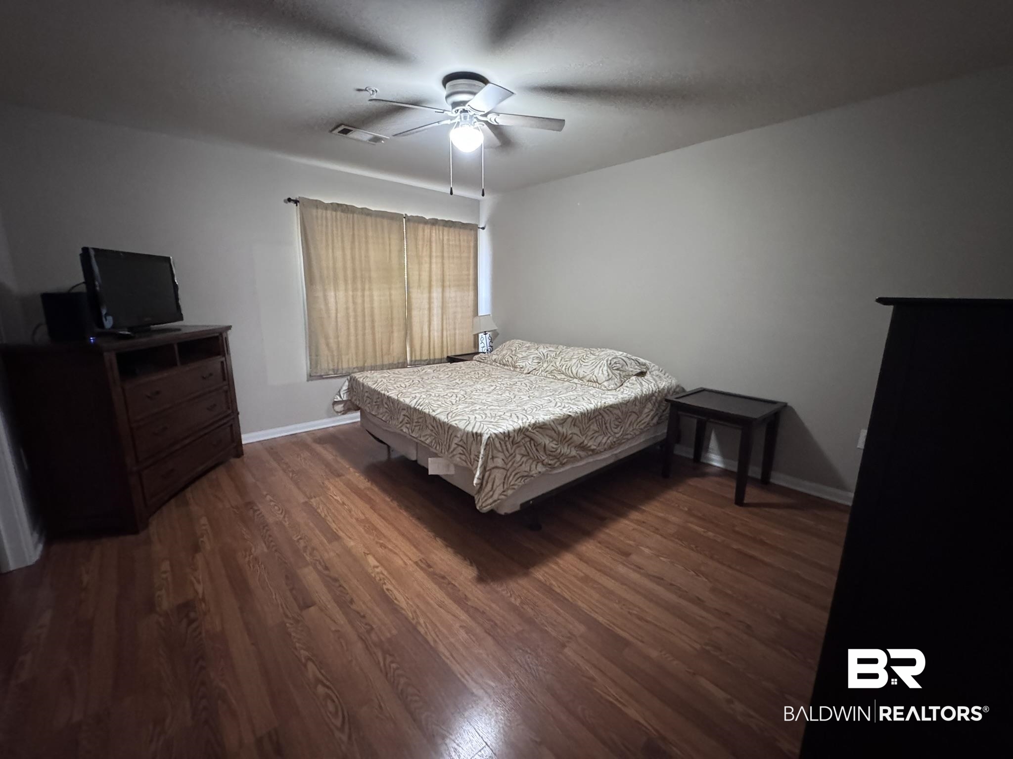 1517 Regency Road, Unit 131 Gulf Shores, AL 36542 - Photo 14 of 21 Bedroom featuring dark wood finished floors and ceiling fan
