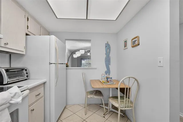 a dining room with furniture and a refrigerator