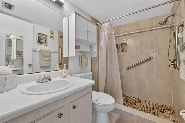 a bathroom with a sink toilet a mirror and shower