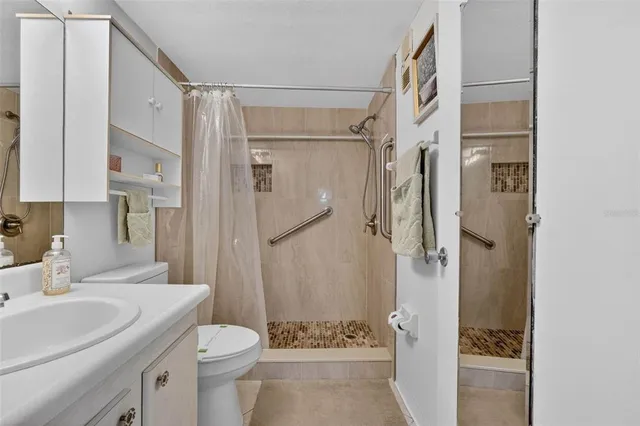 a bathroom with a granite countertop sink toilet and shower