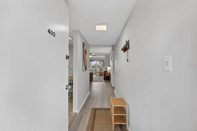 a view of a hallway with wooden floor and furniture
