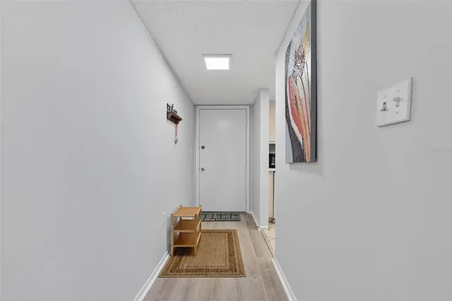 a view of a livingroom with wooden floor and a white bed