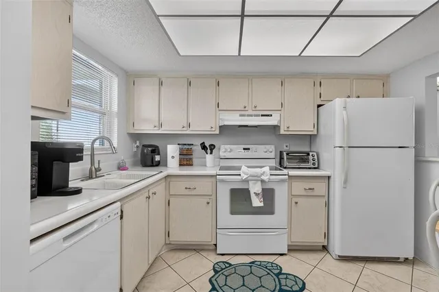 a kitchen with a refrigerator sink and cabinets