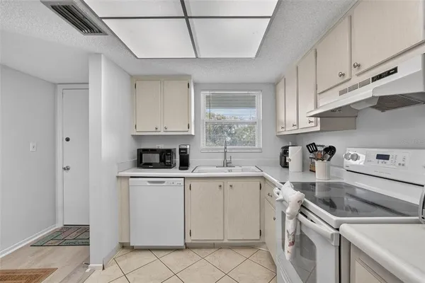 a kitchen with cabinets appliances a sink and a window