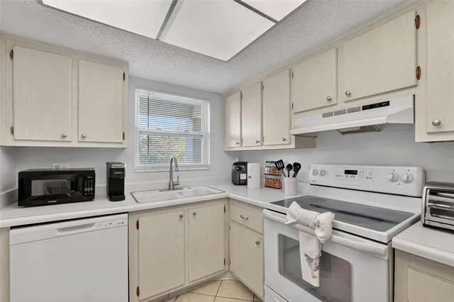 a kitchen with white cabinets and white appliances