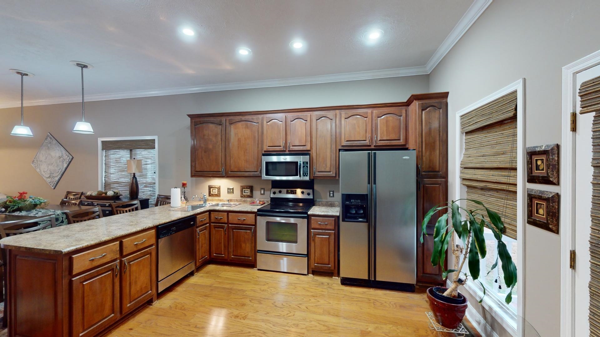 19 Aqua Drive Iuka, MS 38852 - Photo 4 of 33 a kitchen with stainless steel appliances granite countertop a refrigerator a sink dishwasher a oven and a dining table with wooden floor