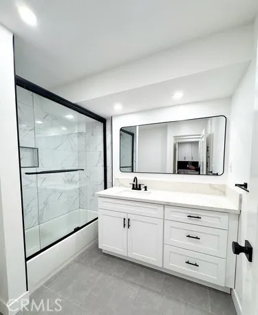 a bathroom with a double vanity sink mirror and bathtub