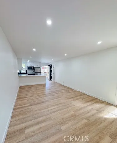 a view of kitchen with kitchen island microwave and wooden floor