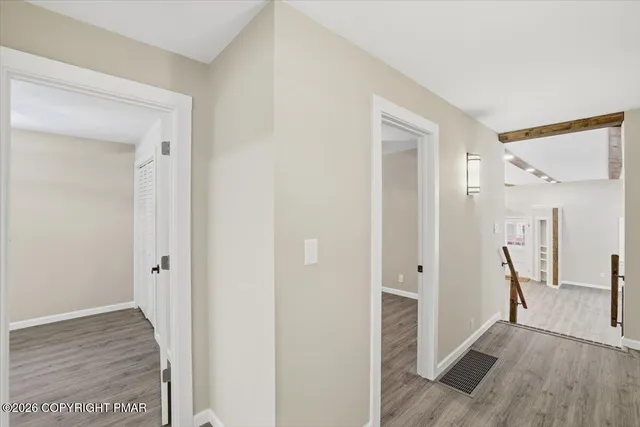 a view of a hallway with wooden floor and closet area