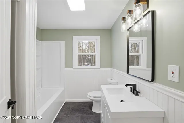 a bathroom with a sink and mirror with toilet