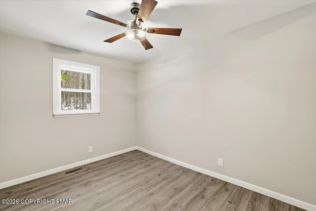 an empty room with a window and a fan