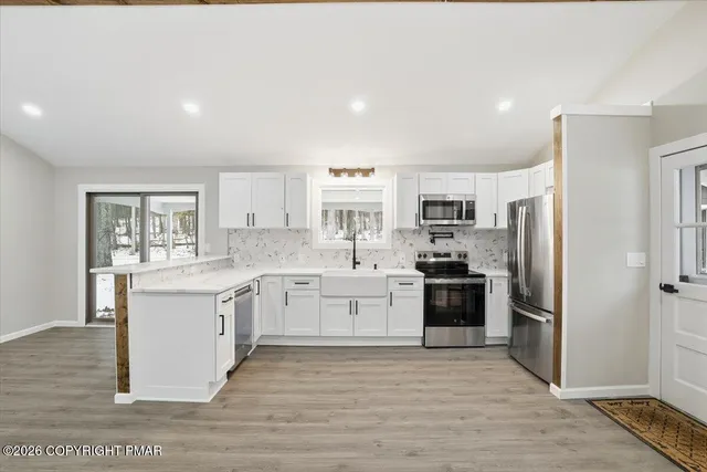 a large kitchen with stainless steel appliances granite countertop a stove and a refrigerator