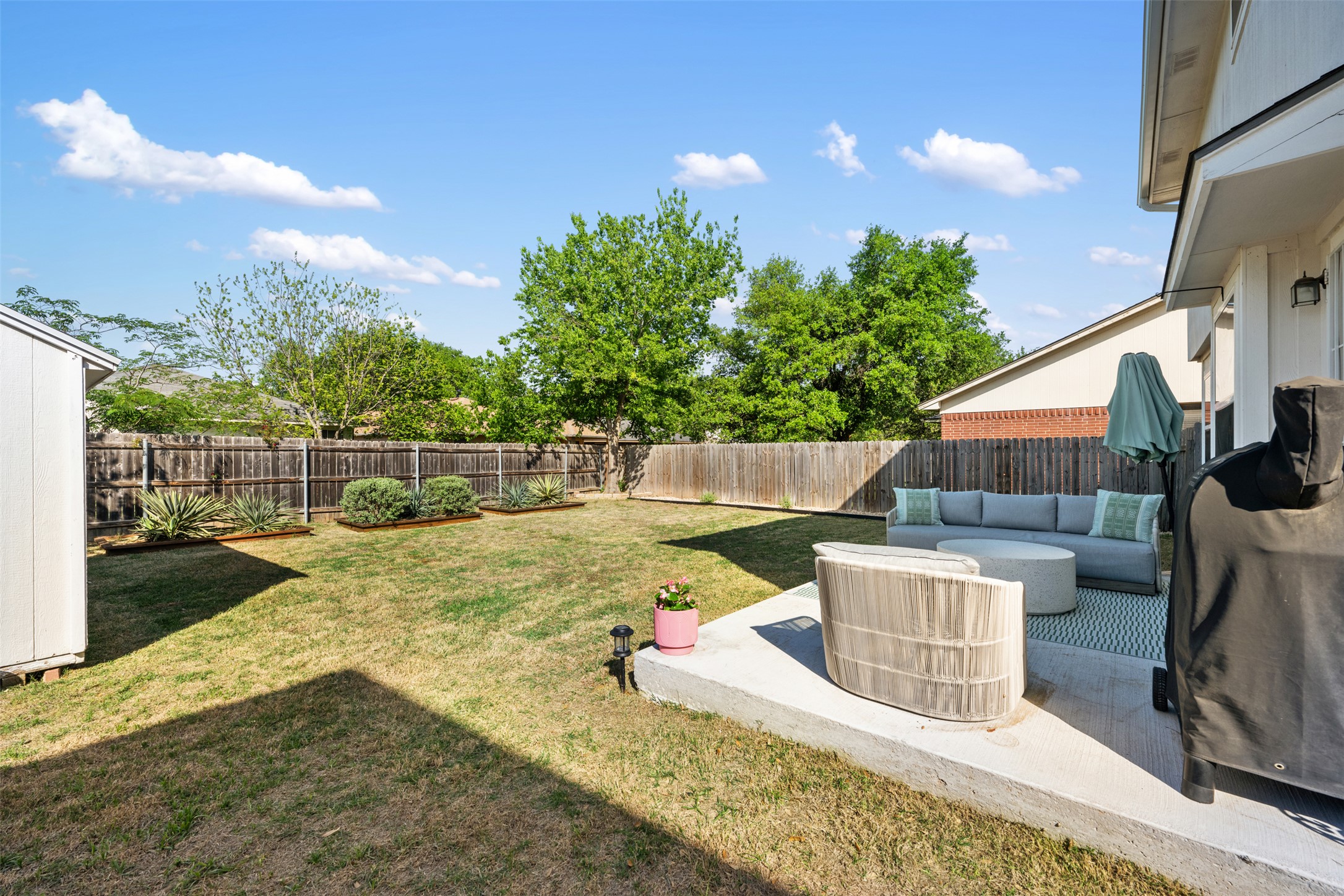 3116 Port Anne Way Leander, TX 78641 - Photo 23 of 24 Backyard featuring a concrete patio, wood fence, and a storage shed