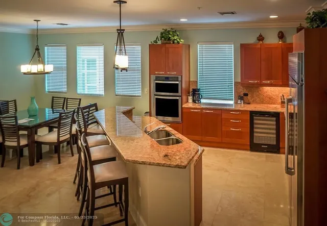 a kitchen with granite countertop a refrigerator stove and sink