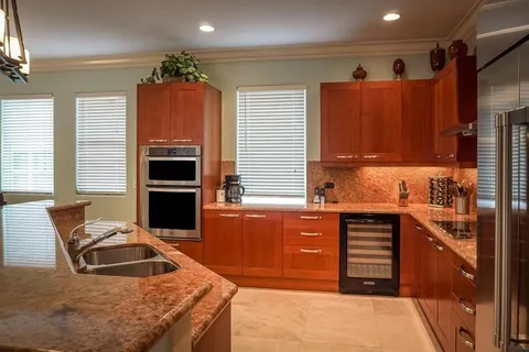 a kitchen with stainless steel appliances granite countertop a refrigerator stove and sink