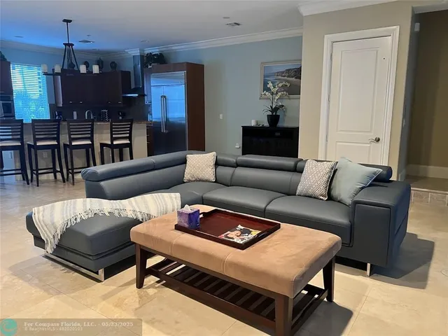 a kitchen with stainless steel appliances granite countertop a refrigerator a stove a sink a dining table and chairs with wooden floor