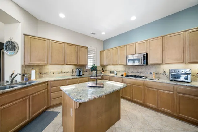 a dining hall with stainless steel appliances kitchen island granite countertop furniture and a large window