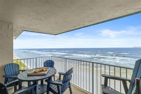 a balcony with table and chairs