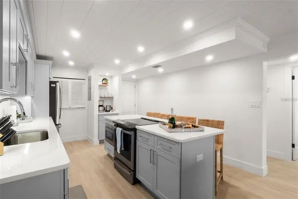 a kitchen that has a sink a stove and a refrigerator