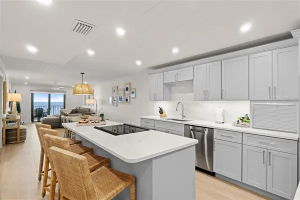 a kitchen that has a sink a stove counter space and wooden floor