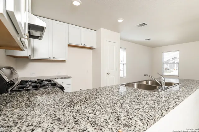 a bedroom with granite countertop a sink and a stove top oven