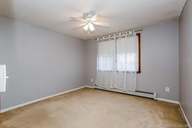 an empty room with chandelier fan