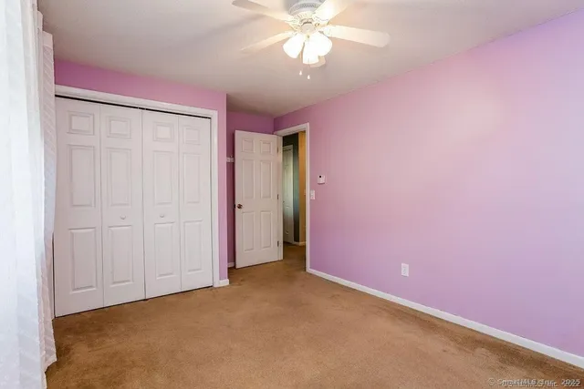 an empty room with a ceiling fan and a window