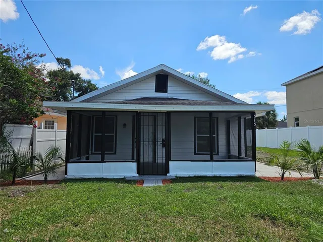 a view of a house with potted plants and a table