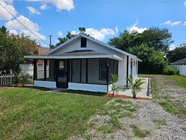 a view of a house with a yard and sitting area