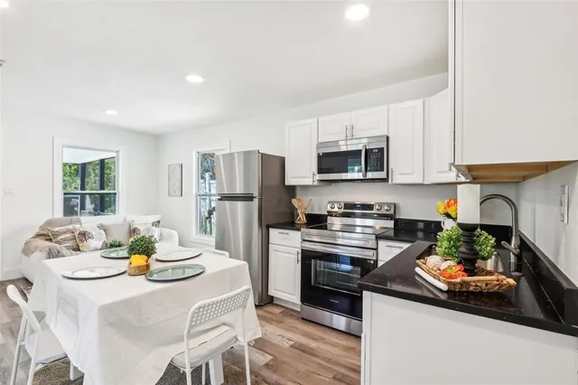 a kitchen with stainless steel appliances a stove a sink a refrigerator and a refrigerator