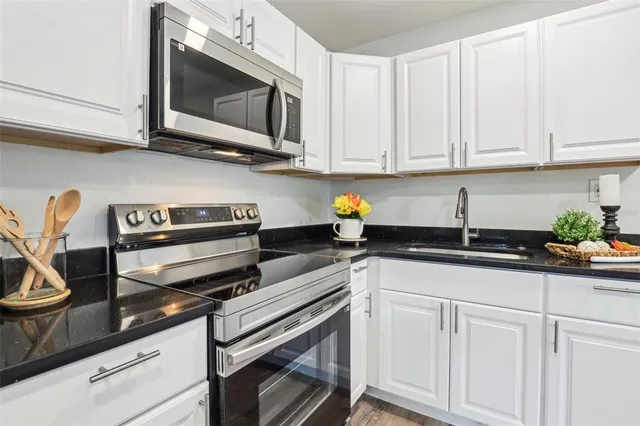 a kitchen with cabinets stainless steel appliances and a wooden floor