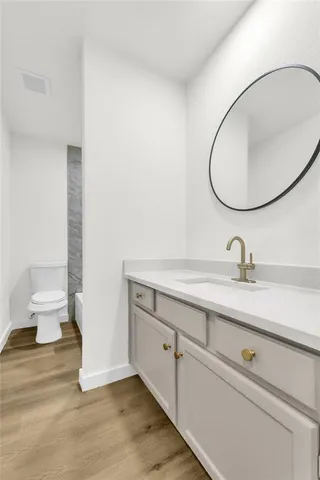 a bathroom with a sink a toilet and a mirror