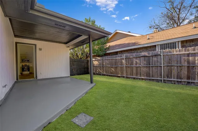 a view of a backyard with wooden fence