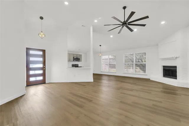 a view of empty room with wooden floor and window