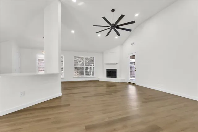 a view of empty room with wooden floor and window