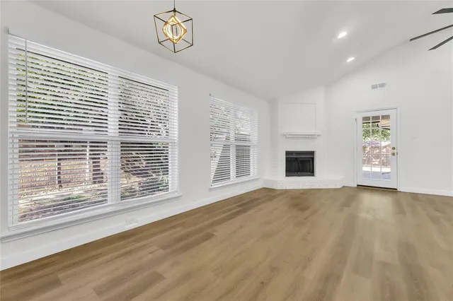 a view of an empty room with a window and a fireplace