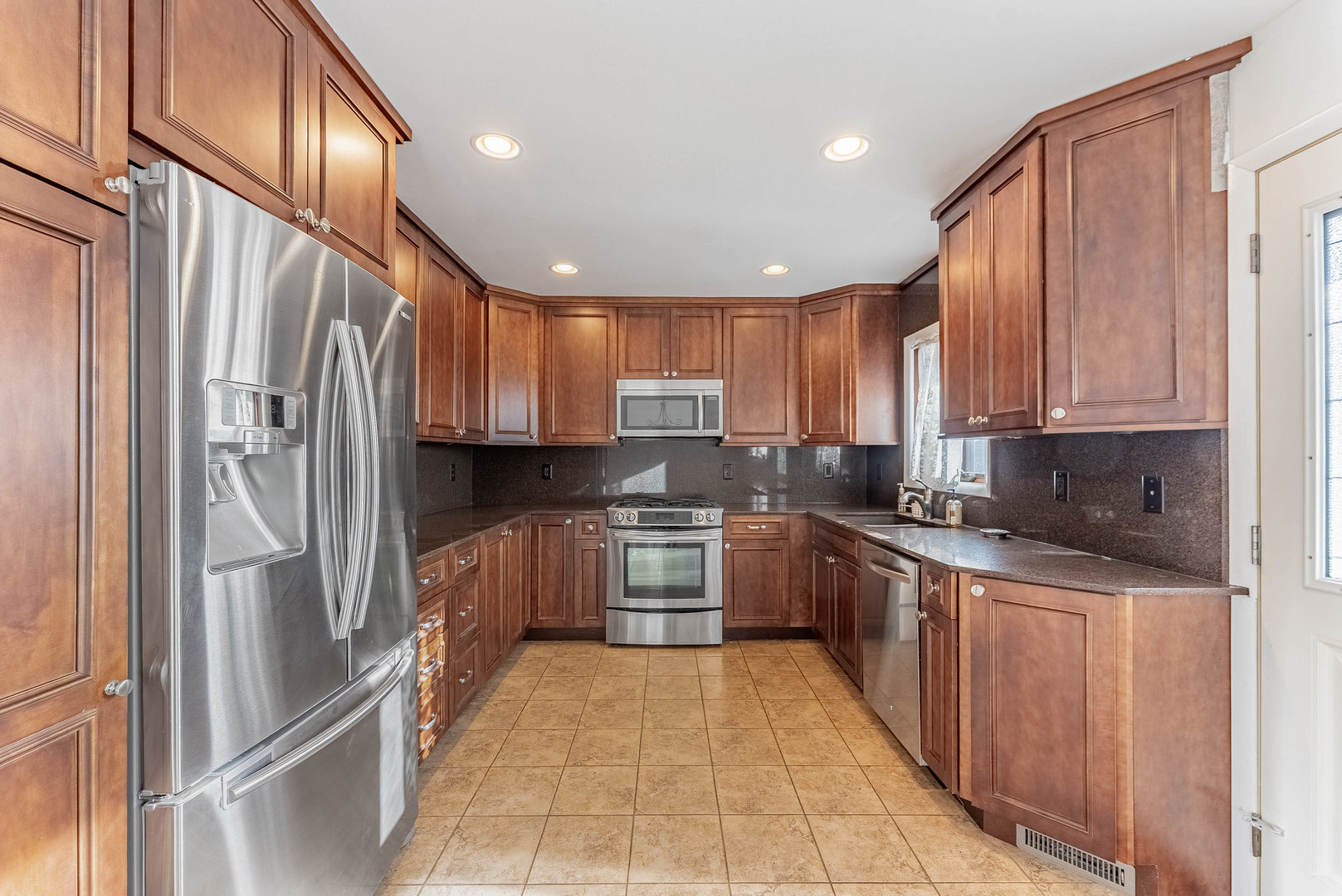 729 Yates Avenue Romeoville, IL 60446 - Photo 7 of 18 a kitchen with stainless steel appliances granite countertop a refrigerator oven a sink dishwasher and wooden cabinets with wooden floor