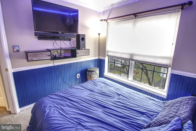 a living room with stainless steel appliances furniture a rug and a window