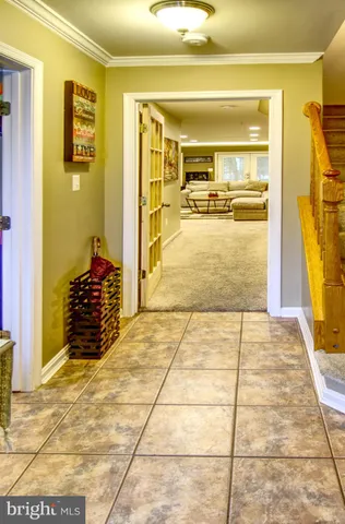 a view of a hallway with wooden floor and a bathroom