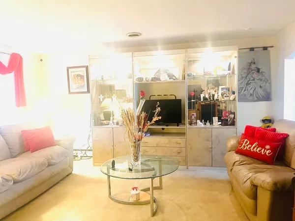 a living room with furniture a couch and a floor to ceiling window