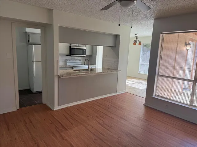 a view of kitchen with wooden floor electronic appliances and window