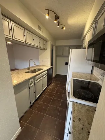a kitchen with a sink a stove and refrigerator