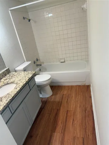a bathroom with a granite countertop bathtub a toilet and a shower