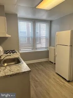 a kitchen with granite countertop a sink and a refrigerator